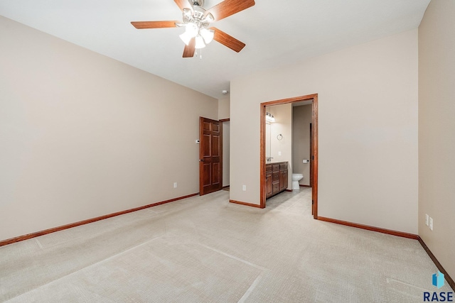 unfurnished bedroom featuring light carpet, ensuite bath, and ceiling fan