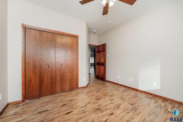 unfurnished bedroom with ceiling fan, a closet, and light wood-type flooring