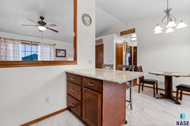 kitchen with a kitchen breakfast bar, ceiling fan with notable chandelier, vaulted ceiling, decorative light fixtures, and kitchen peninsula