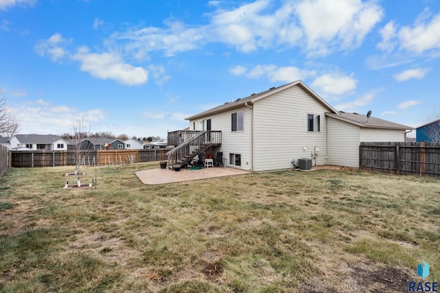 rear view of house featuring central AC unit, a deck, a yard, and a patio