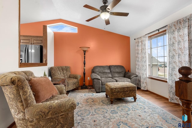 living room featuring ceiling fan, light hardwood / wood-style floors, and lofted ceiling