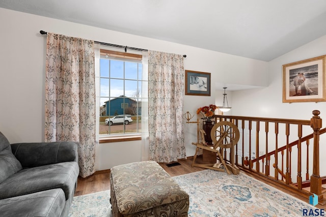 sitting room with hardwood / wood-style flooring and vaulted ceiling