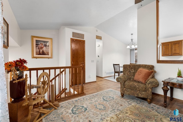 sitting room with light hardwood / wood-style flooring, lofted ceiling, and a notable chandelier