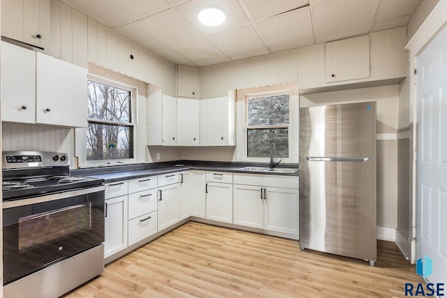 kitchen featuring white cabinets, appliances with stainless steel finishes, light wood-type flooring, and sink