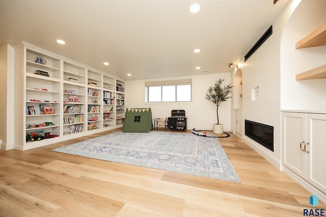 sitting room with built in shelves and light wood-type flooring