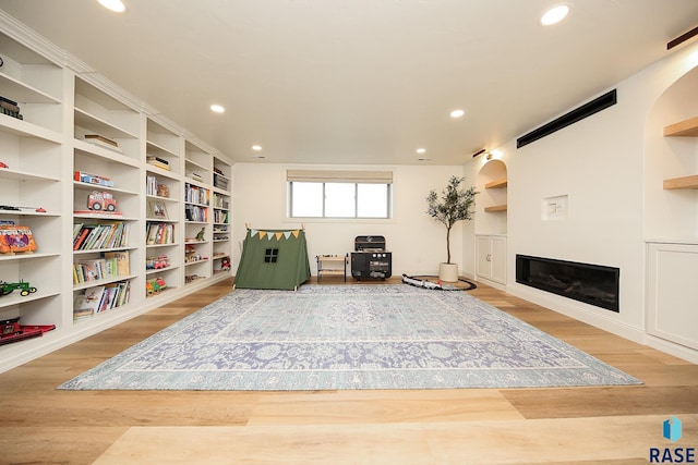 sitting room featuring hardwood / wood-style floors and built in shelves