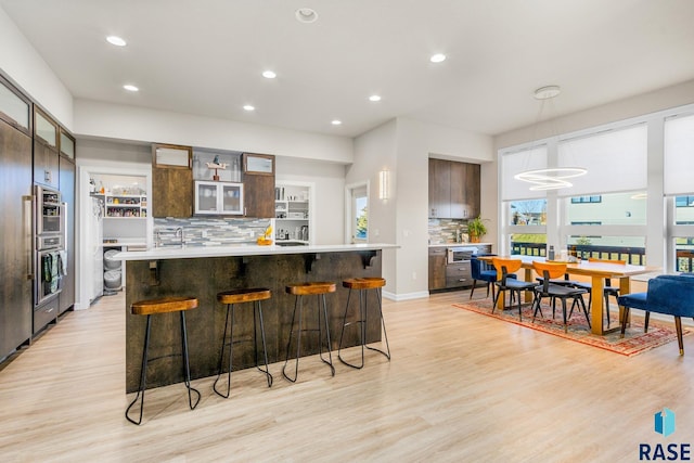 kitchen with tasteful backsplash, light hardwood / wood-style flooring, washer / clothes dryer, and a kitchen island