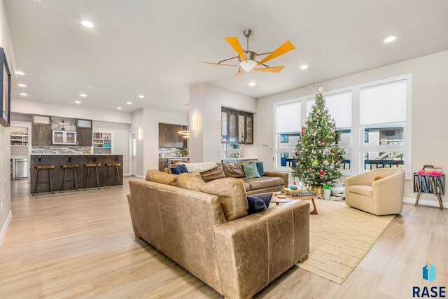 living room featuring light wood-type flooring and ceiling fan