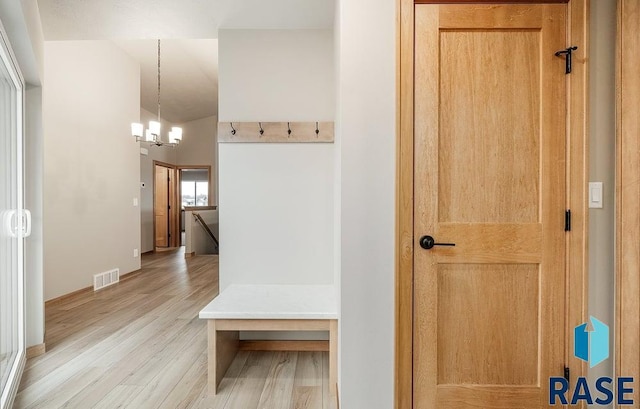 mudroom featuring a notable chandelier and light hardwood / wood-style flooring