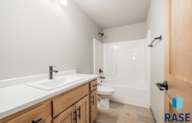 full bathroom featuring wood-type flooring, vanity, toilet, and  shower combination