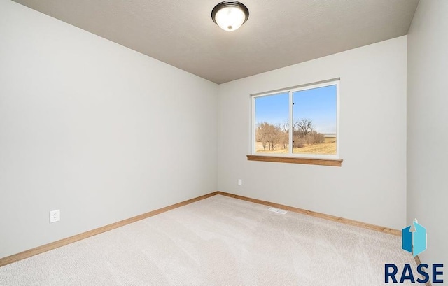 carpeted empty room featuring a textured ceiling