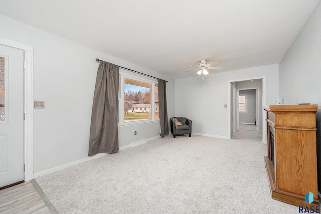 living area featuring ceiling fan and light colored carpet