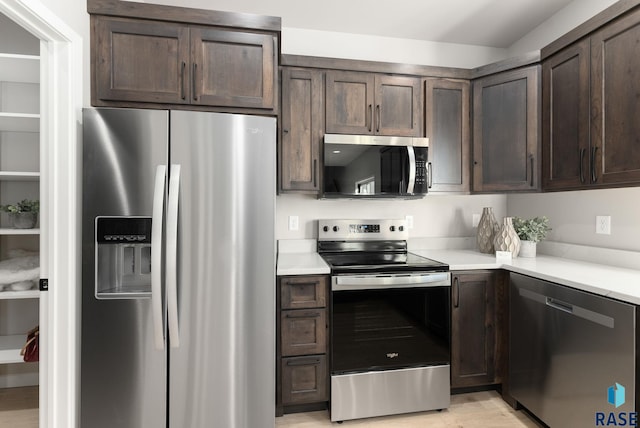 kitchen featuring dark brown cabinetry and appliances with stainless steel finishes