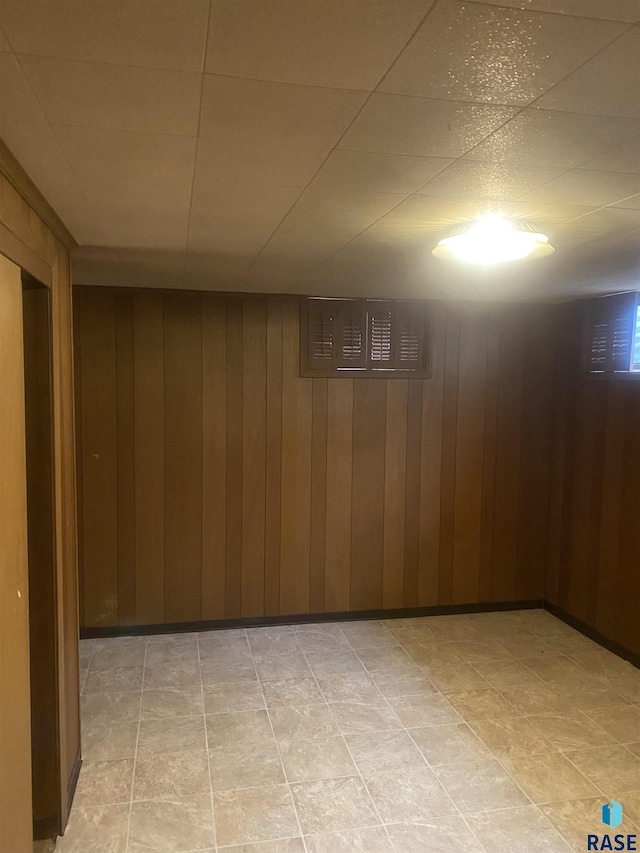 basement featuring wood walls