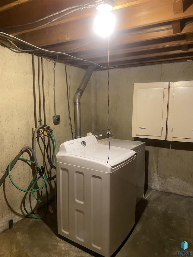 clothes washing area with cabinets and independent washer and dryer