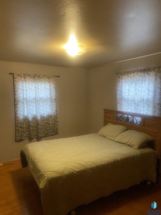 bedroom featuring multiple windows and hardwood / wood-style floors