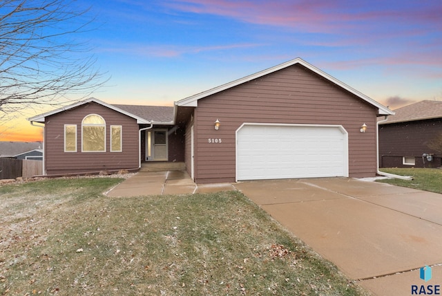 single story home with a yard and a garage