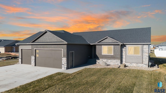 view of front of home with a garage and a yard