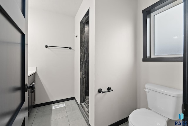 bathroom with tile patterned floors, a shower, vanity, and toilet