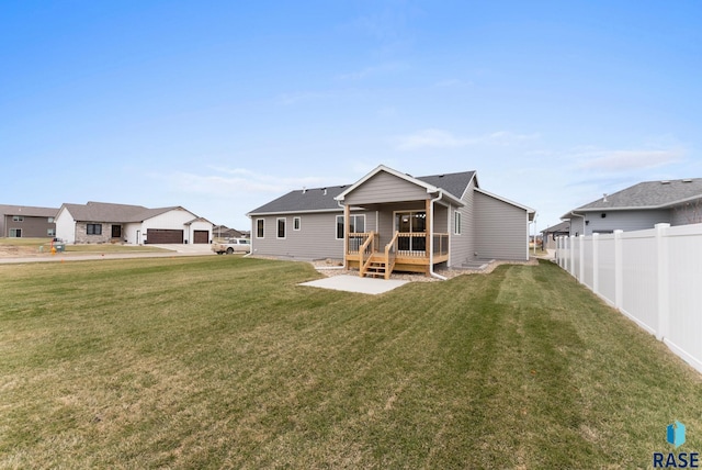 rear view of house featuring a lawn and a deck