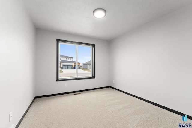 spare room with carpet and a textured ceiling