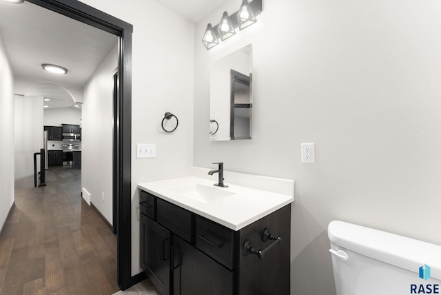 bathroom with vanity, toilet, and wood-type flooring