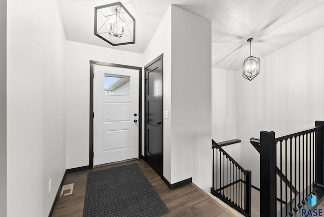 entryway featuring dark hardwood / wood-style flooring and a notable chandelier