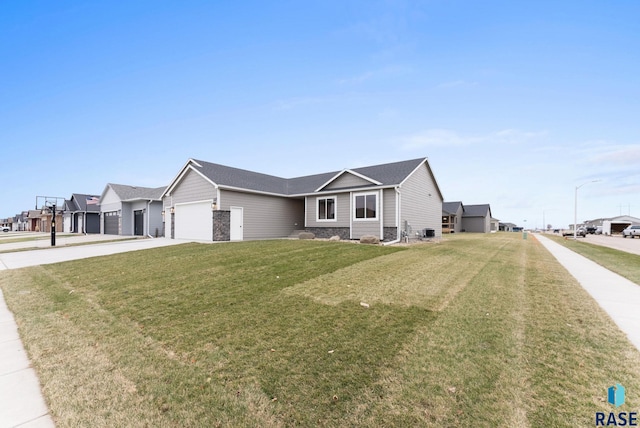 single story home with a garage, a front yard, and central AC