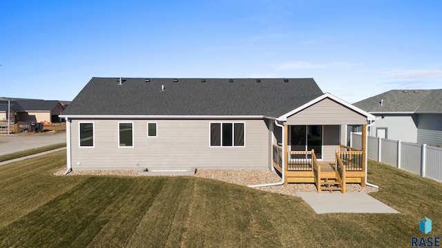 rear view of house featuring a wooden deck and a yard