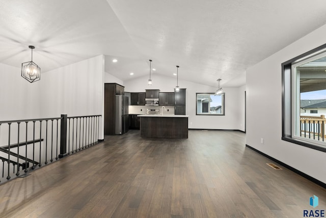 kitchen with lofted ceiling, dark hardwood / wood-style floors, decorative light fixtures, a kitchen island, and stainless steel appliances