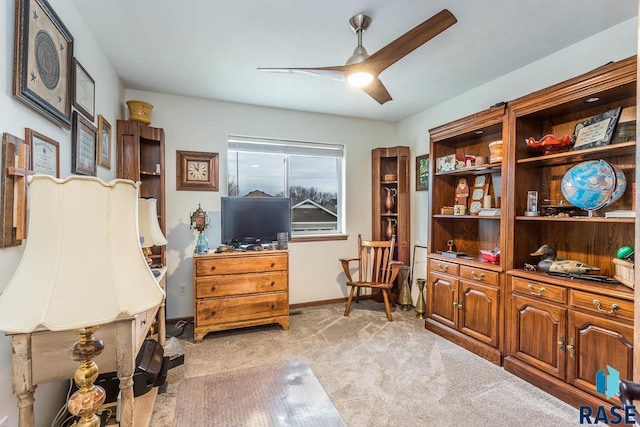 carpeted office space featuring ceiling fan