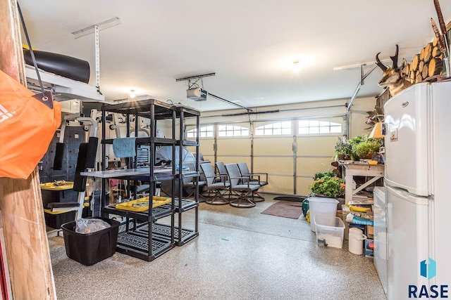 garage featuring white fridge and a garage door opener