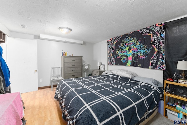 bedroom with hardwood / wood-style flooring and a textured ceiling