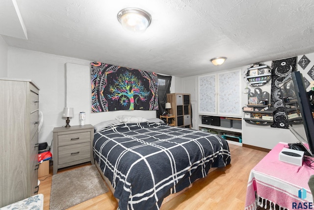 bedroom featuring light hardwood / wood-style floors and a textured ceiling