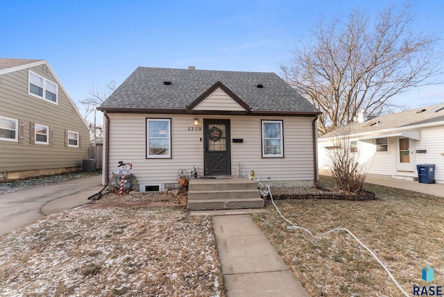 bungalow-style home with central air condition unit