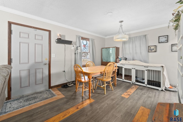 dining area featuring a textured ceiling, crown molding, and dark wood-type flooring