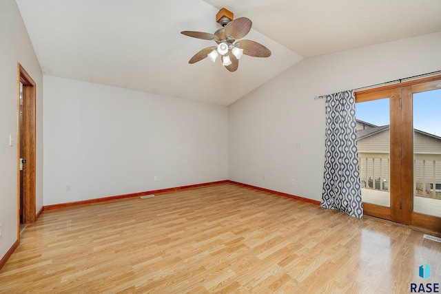 unfurnished room with ceiling fan, french doors, light hardwood / wood-style floors, a textured ceiling, and vaulted ceiling