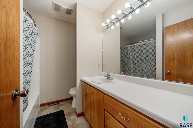 bathroom featuring tile patterned flooring, vanity, toilet, and a textured ceiling