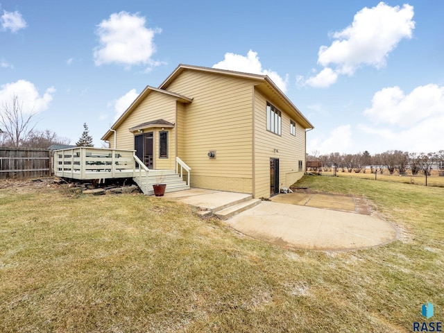 rear view of house featuring a deck, a yard, and a patio