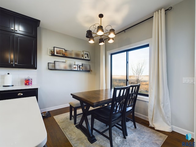 dining space featuring dark wood-type flooring and a notable chandelier