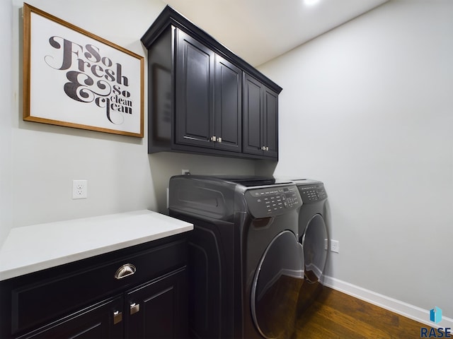 washroom with cabinets, washing machine and dryer, and dark hardwood / wood-style floors