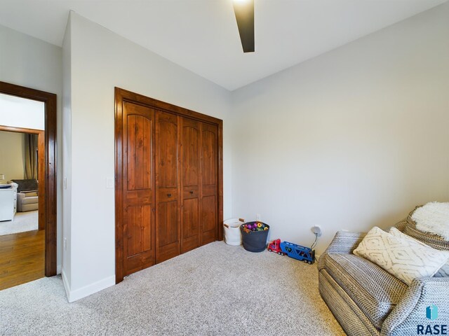 sitting room with carpet flooring and ceiling fan