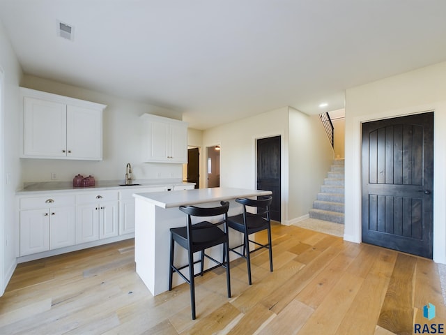 kitchen featuring white cabinets, a center island, and light hardwood / wood-style floors