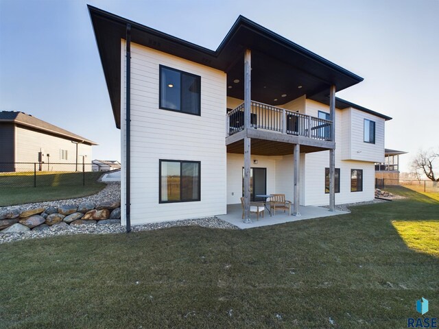 back of house with a lawn, a balcony, and a patio