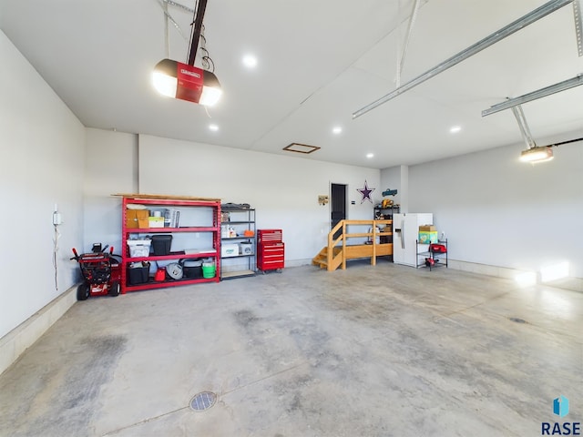 garage with white refrigerator with ice dispenser and a garage door opener