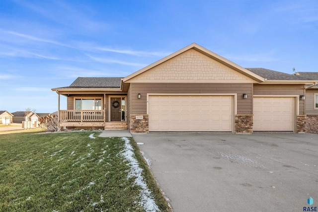 single story home featuring a front yard, a porch, and a garage