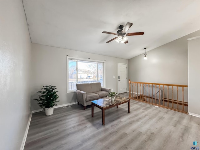 living room with light hardwood / wood-style floors, ceiling fan, and lofted ceiling