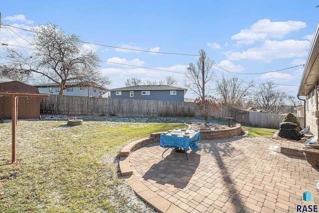 view of yard featuring a patio, a fire pit, and a storage shed