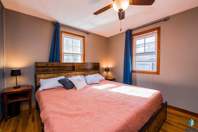 bedroom with dark hardwood / wood-style flooring and ceiling fan