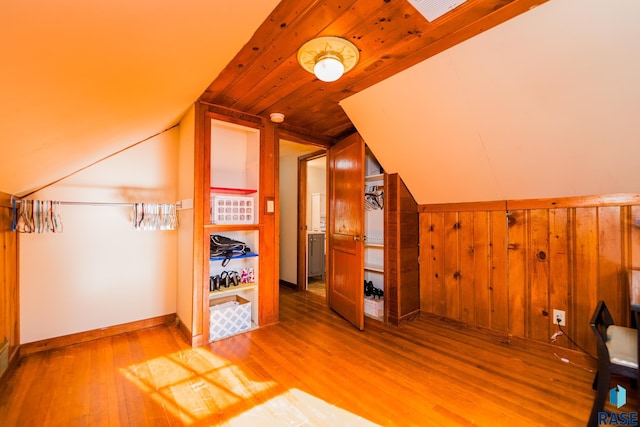 additional living space featuring hardwood / wood-style flooring, vaulted ceiling, wood walls, and wood ceiling